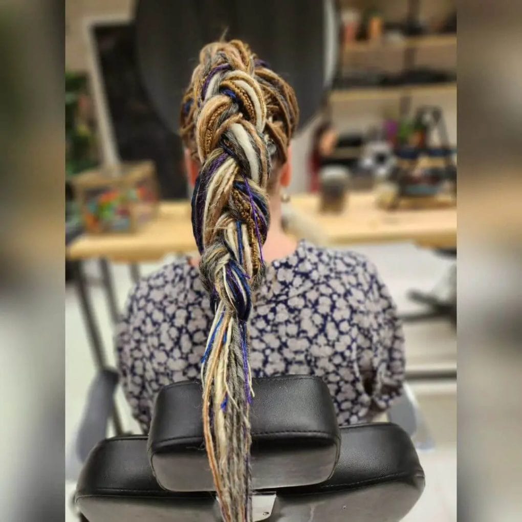 Large braid of dreadlocks enhanced with vibrant hues and intricate threading.