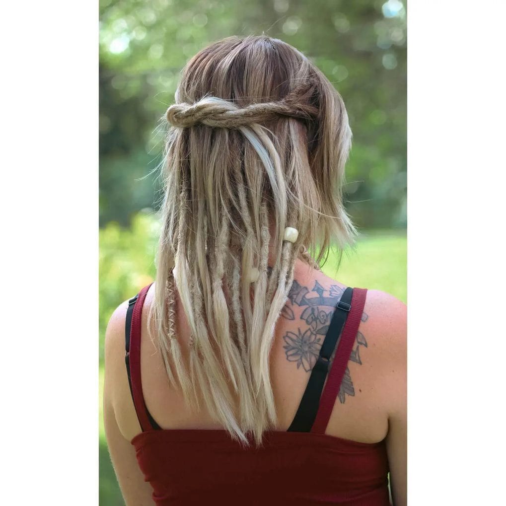 Blonde dreadlocks adorned with light thread and white beads, fashioned into a crown-like wrap.