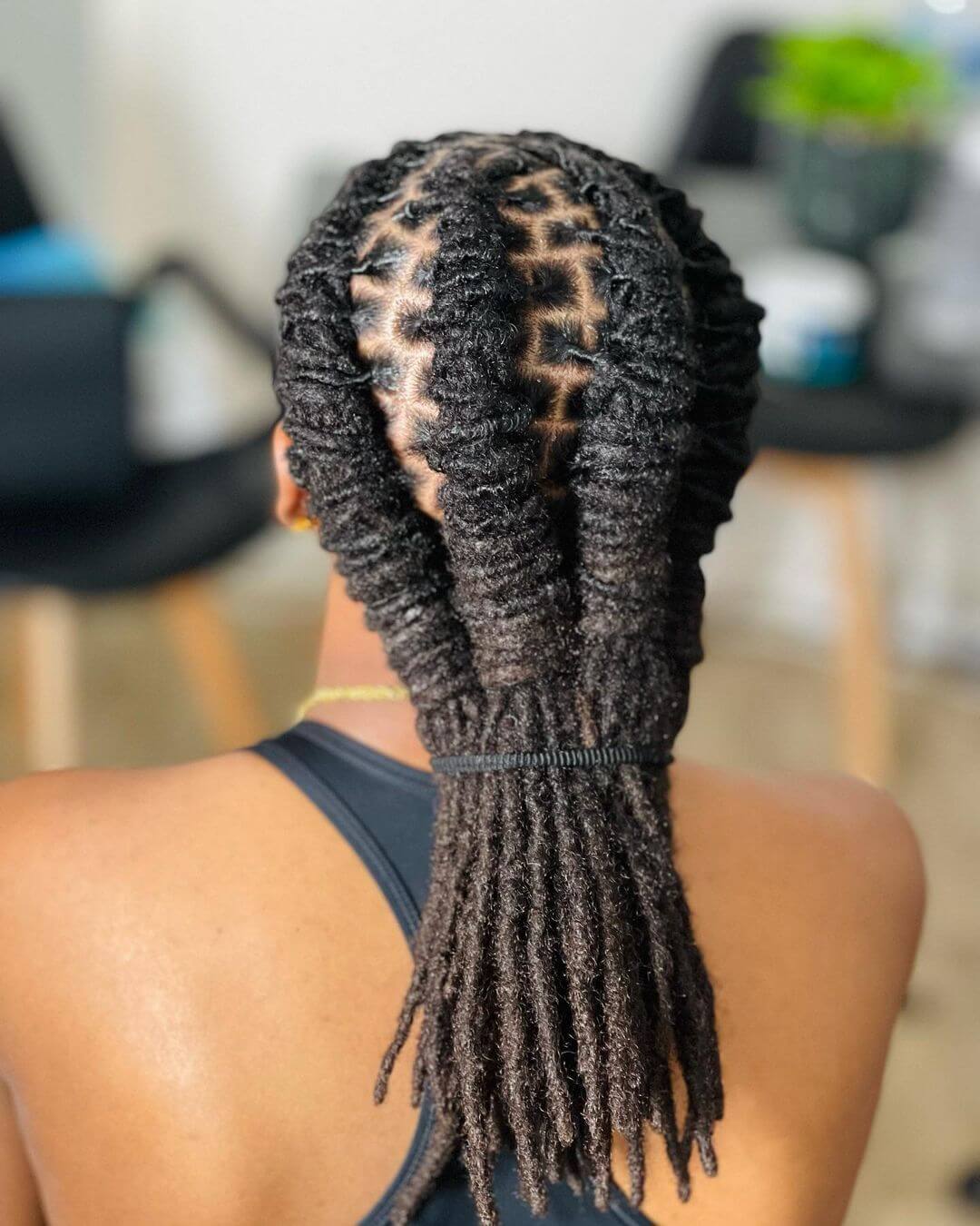 Shoulder-length dreadlocks twisted into braids and elegantly swept back.