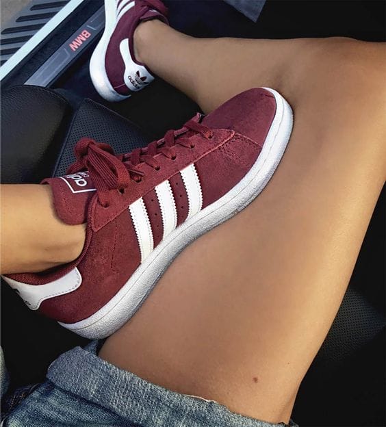 Athletic burgundy suede sneakers with white stripes, featuring a grippy rubber sole and padded collar, perfect for casual and sporty outfits.