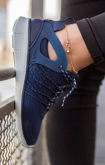 Sleek navy sneaker featuring a breathable mesh upper, cut-out section, flexible rubber sole, and elegant ankle chain. Perfect for casual wear.