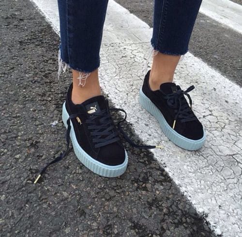 Black suede sneakers with textured finish and light mint rubber platform sole, styled with distressed ankle-length jeans. Perfect for casual wear.