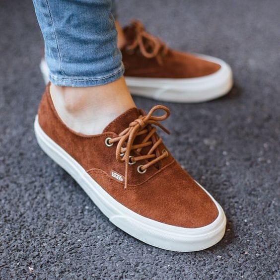 Brown suede sneakers with flat laces and a white rubber sole, perfect for casual wear and outdoor activities.