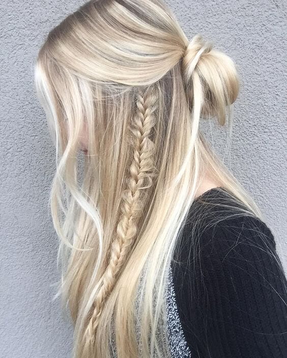 Half up half down hairstyle with a loose bun at the crown, flowing strands on the sides, showcasing a neat braid. Perfect for casual or semi-formal occasions.