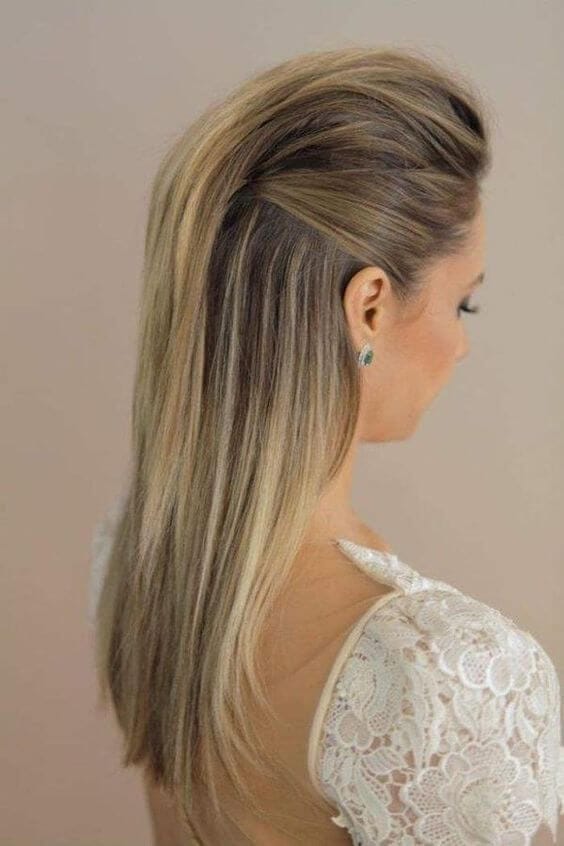 Long hair styled in a half up, half down bun with a voluminous top and smooth strands, perfect for formal events.