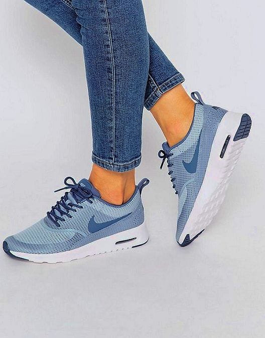 Lightweight blue women's sneakers with dark accents, cushioned midsole for comfort, and textured white outsole for traction. Perfect for casual wear.