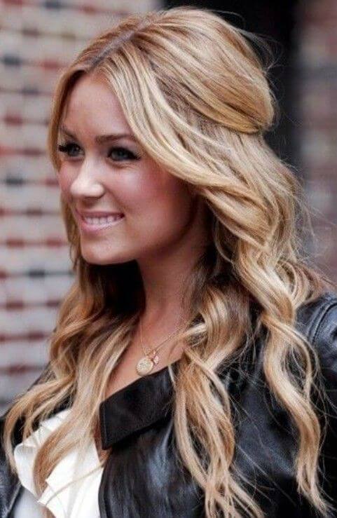 Loose, cascading waves styled in a half-up, half-down bun, with sandy blonde hair and lighter highlights, offering a polished, elegant look.
