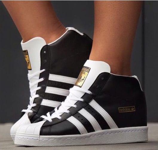 High-top sneaker shoes for women in sleek black and white, featuring three stripes, rubber toe cap, and padded collar for comfort.