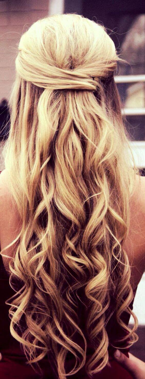 Loose curls styled in a half-up bun, featuring 24-inch warm blonde waves. Ideal for formal occasions, showcasing elegance and softness.