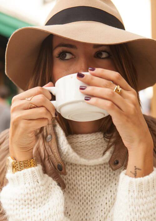 A stylish wide-brimmed beige winter hat paired with a cozy cream sweater, perfect for a relaxed outdoor setting.