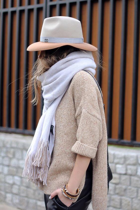 Wide-brimmed beige winter hat with subtle band, paired with a relaxed beige sweater and light gray scarf, perfect for cool fashion.