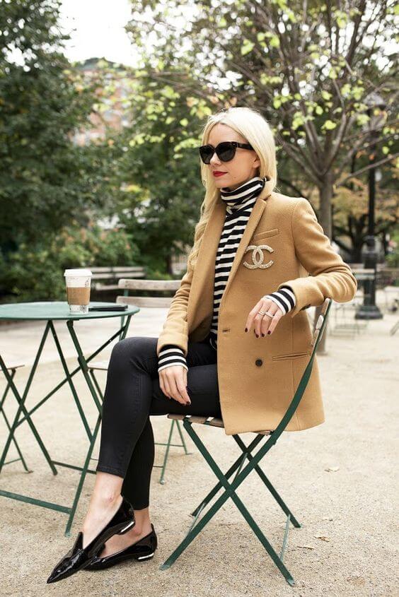 Elegant outfit featuring a tailored tan blazer, black and white striped turtleneck, and shiny black loafers, perfect for fall outings.