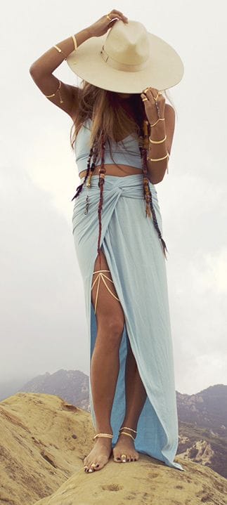 Wide-brimmed straw hat paired with a light blue wrap skirt and crop top, perfect for sun protection in warm climates.