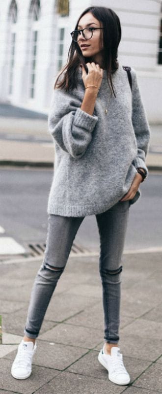 Casual outfit with a grey oversized sweater and light grey skinny jeans. Paired with white sneakers, perfect for trendy, comfortable wear.