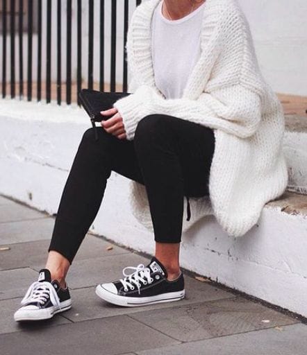 Cozy oversized white cardigan over a white t-shirt, paired with fitted black leggings and classic black and white sneakers.