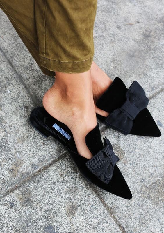 Elegant black velvet mules with a pointed toe and large bow, perfect for casual or semi-formal summer outfits.