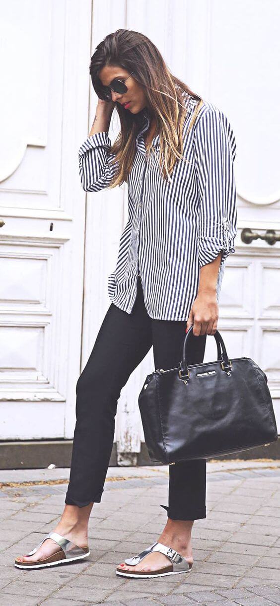 Casual summer outfit featuring chunky black sandals paired with a striped button-up shirt and fitted black pants, perfect for relaxed styling.