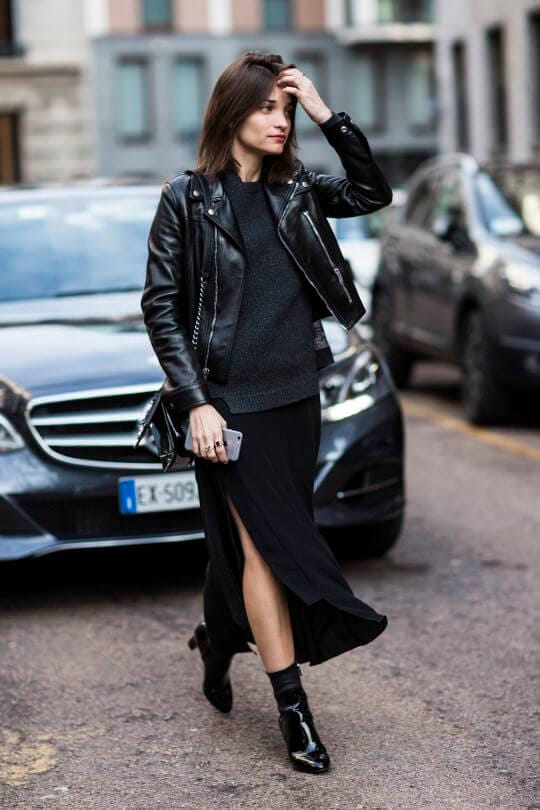 Medium-length, loose waves frame the model's face, accentuating her chic black and white mini skirt outfit, embodying elegant spring fashion.