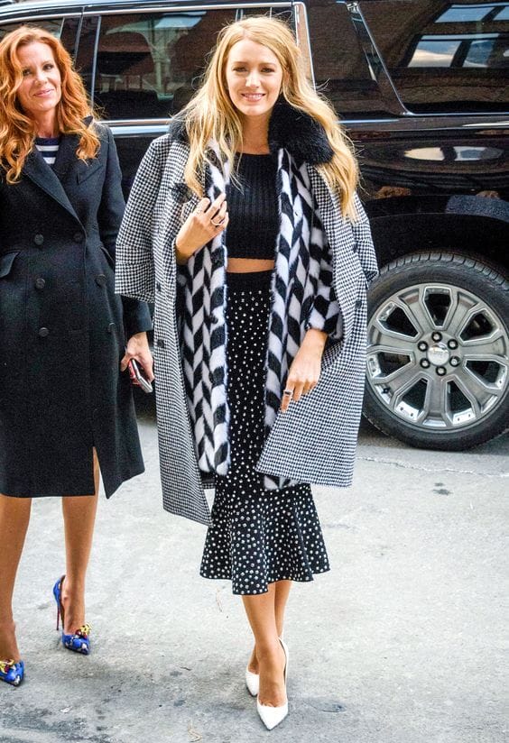 Chic black and white outfit featuring a checkered overcoat, fitted crop top, and polka dot mermaid skirt, styled for elegance.