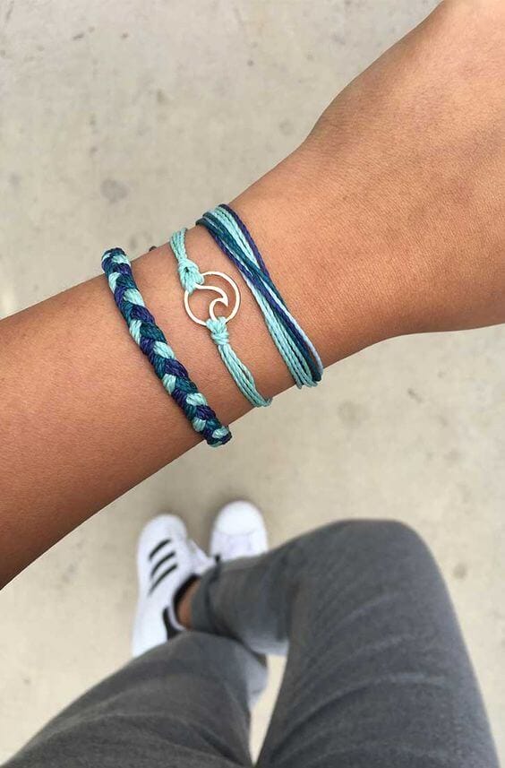 Colorful bracelets for women feature a braided dark blue and light green design, paired with a simple looped style in blue and aqua.