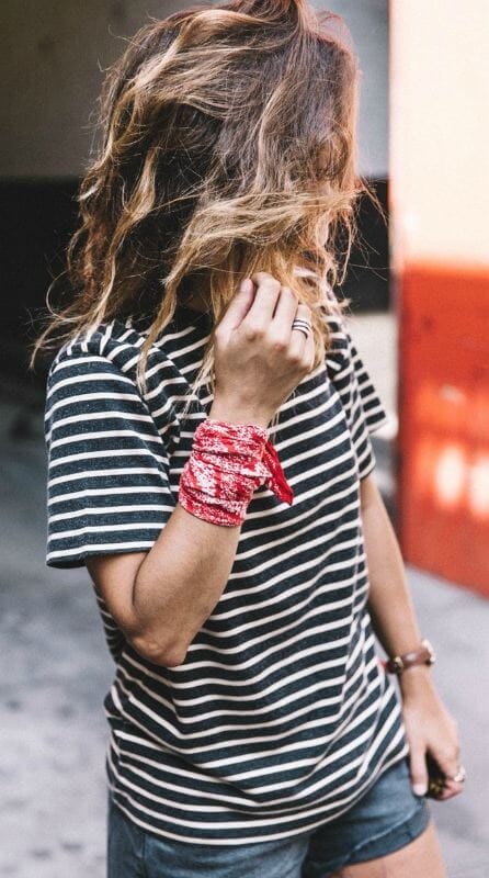 Curly hair with sun-kissed highlights pairs beautifully with a summer scarf, enhancing a chic, casual look for warm days.