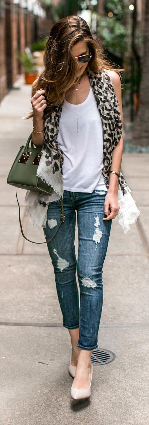 Casual summer outfit featuring fitted denim jeans, a light tank top, and a leopard print scarf draped around the shoulders.