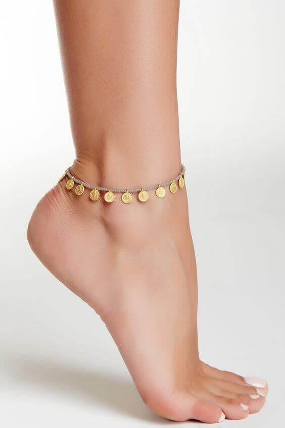 Delicate gold coin anklet made from soft, flexible material, perfect for casual or beachwear. Aesthetic and lightweight design.