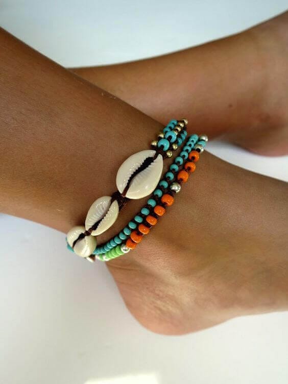 Vibrant boho anklet with multiple strands of light blue, orange, and green beads, featuring natural shell accents for a beachy vibe.