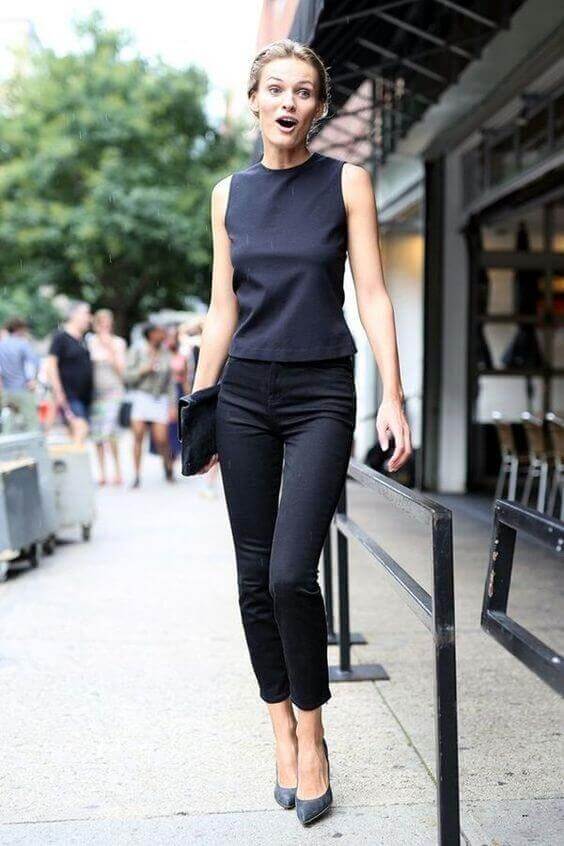 Sleek summer business casual outfit featuring a fitted black sleeveless top and high-waisted black pants, ideal for urban settings.