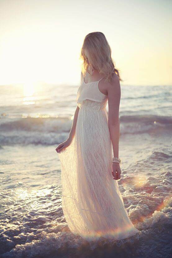 Flowy white sundress with soft beachy waves, perfect for summer. Captures a romantic vibe against a sunset backdrop.
