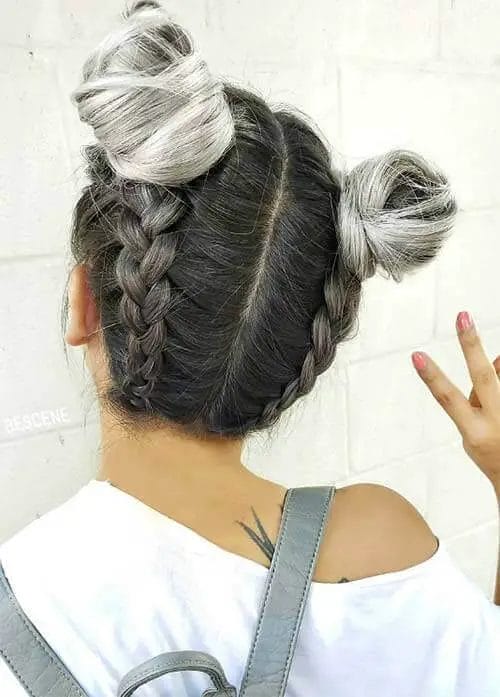 Silver-highlighted space buns with a French braid and sleek gray touch for a vibrant and youthful style.
