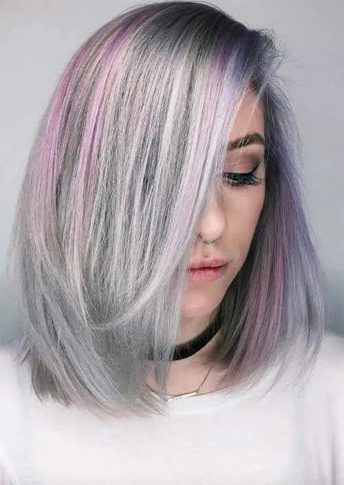 A woman's sleek, straight hairstyle featuring a silvery-gray base with delicate streaks of lavender and muted violet, adorned with subtle layers for dimension and movement, complemented by a side-swept fringe.