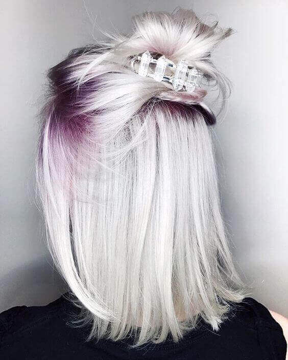 Stylish gray hair with warm blonde highlights, showcasing a smooth transition from dark to silver, enhancing texture and shine.