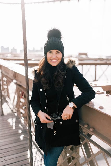 Olive green parka jacket outfit styled for cold weather, paired with winter boots in a snowy outdoor setting.