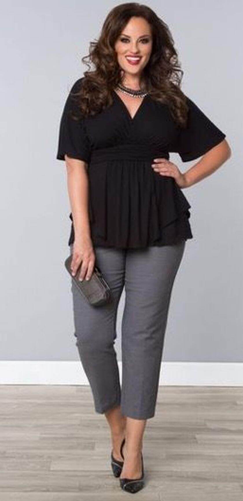Flared peplum top with tailored gray ankle pants, paired with black heels and a chic clutch, perfect for plus size office outfits.