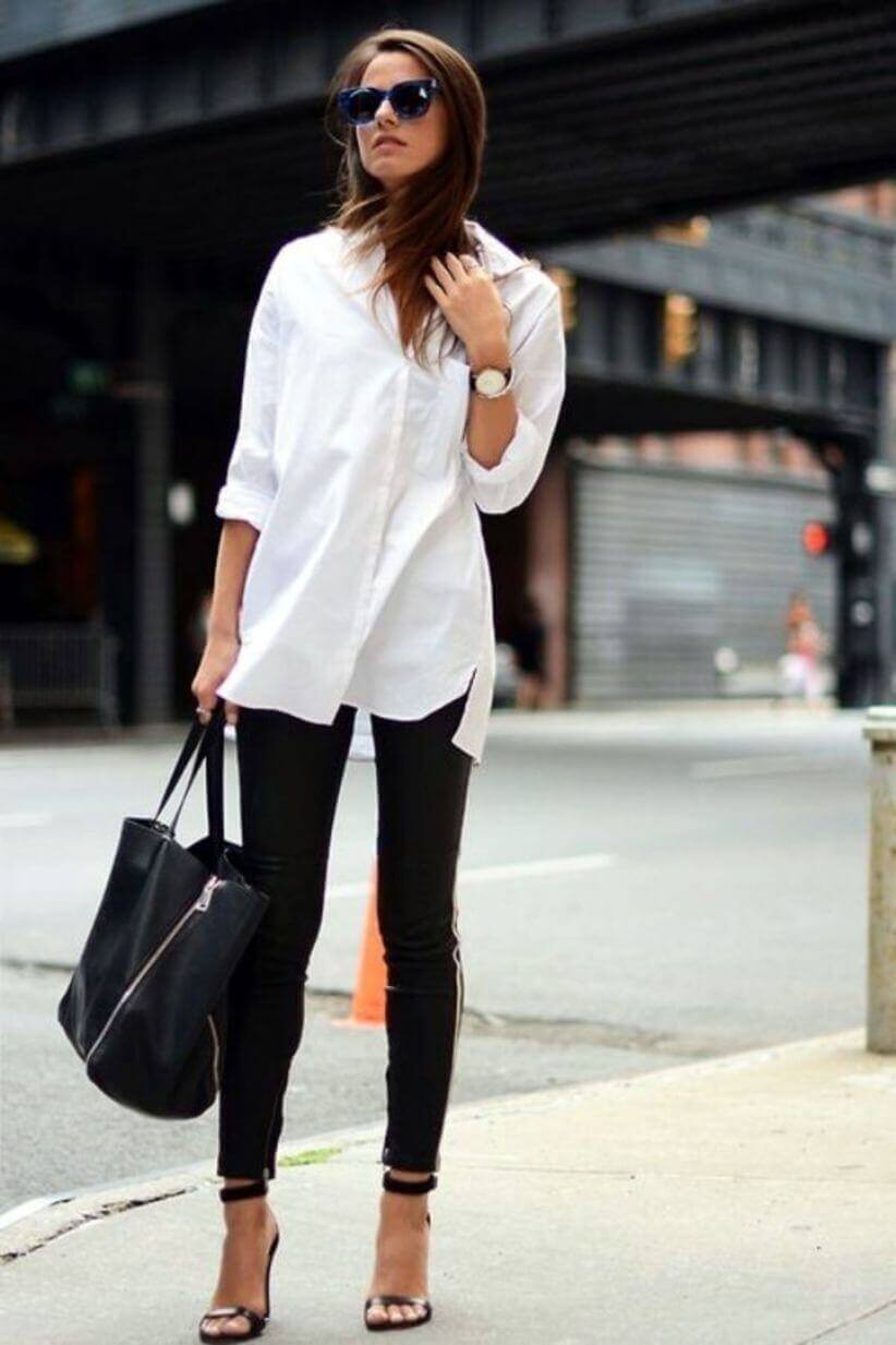 Casual chic outfit with a white oversized button-down shirt and fitted black leather pants. Accessorized with oversized sunglasses and strappy heels.