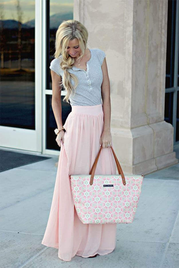Elegant pastel outfit featuring a light gray top and a flowing pink skirt, perfect for spring. Soft textures and a feminine style shine.