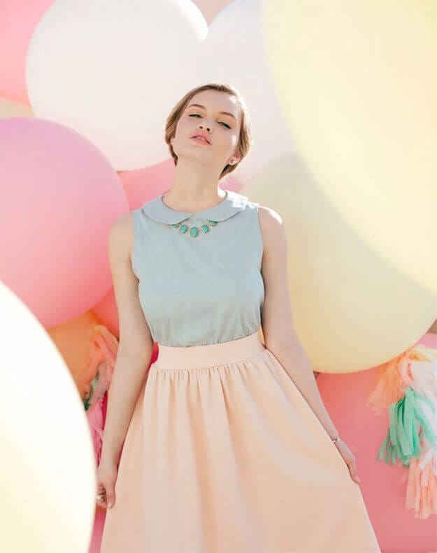 Soft, textured bob hairstyle pairs beautifully with a light blue collared top and flowing peach skirt, embodying pastel outfit inspiration.