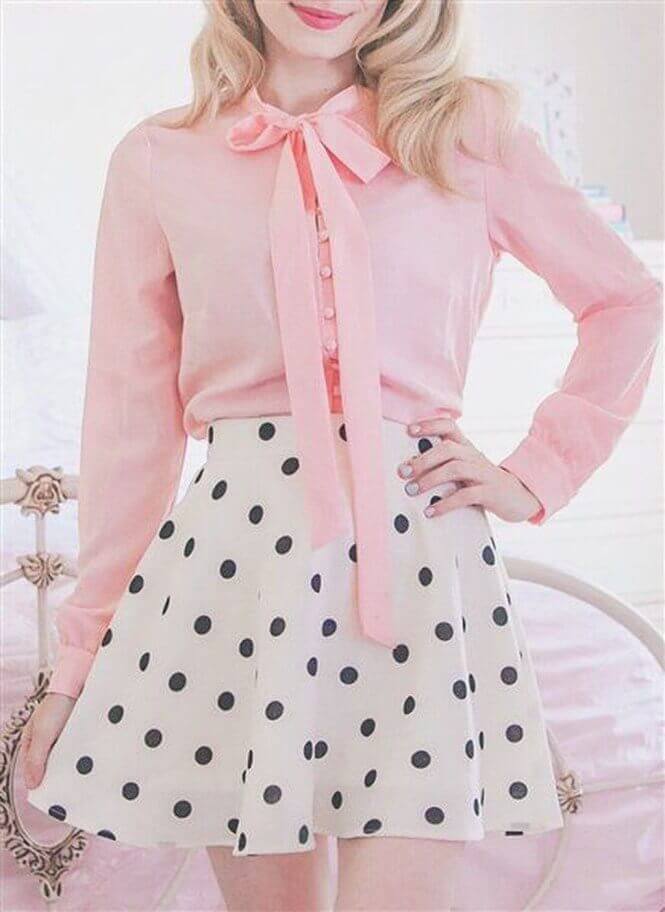 Pale pink blouse with a bow tie and button-down front paired with a high-waisted flared skirt featuring black polka dots.