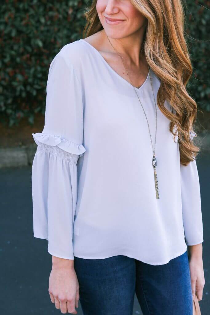 Soft, flowing waves in a light gray blouse with flared sleeves, embodying pastel outfit ideas and soft girl aesthetic for spring.
