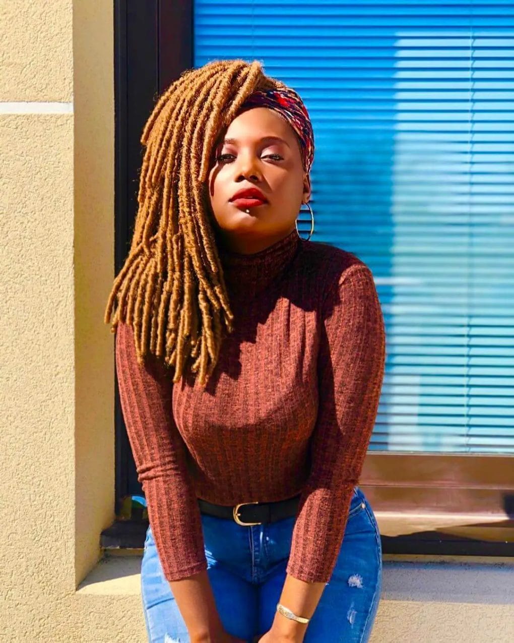 Contrast of radiant copper-colored dreadlocks cascading from crown to shoulders.