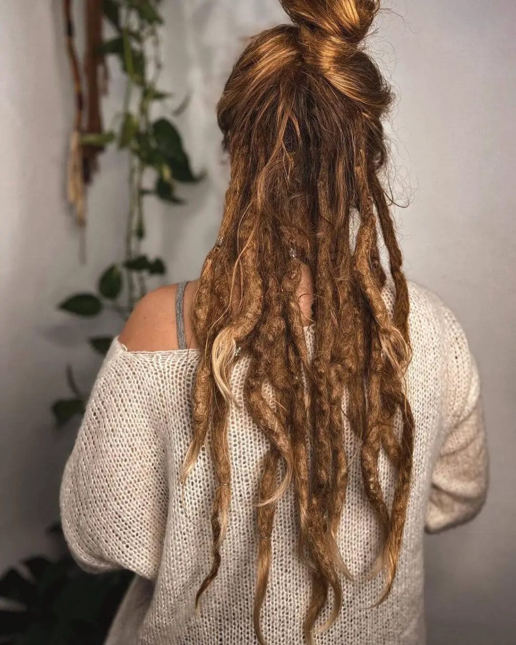 Free-flowing dreads peeking underneath of a hair bun.