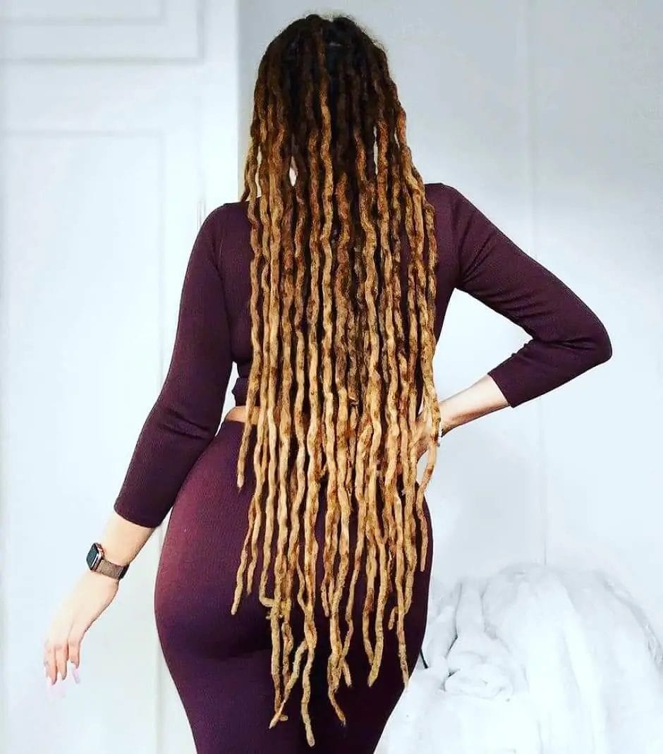 Long dreadlocks balayage transitioning seamlessly from brunette at the roots to blonde at the tips.