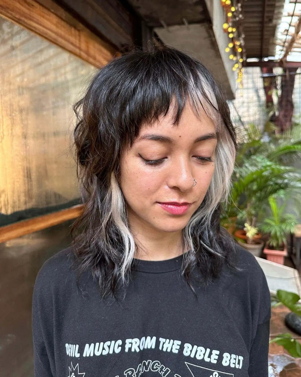 Wolf cut with choppy pixie bangs and platinum highlights.