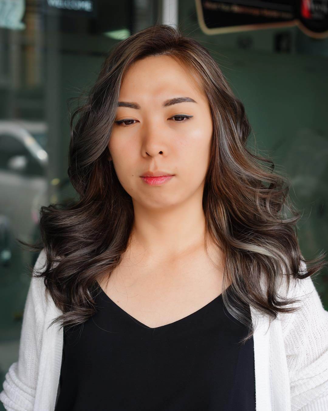 Cool ash brown balayage in waves, with layers enhancing natural volume and movement