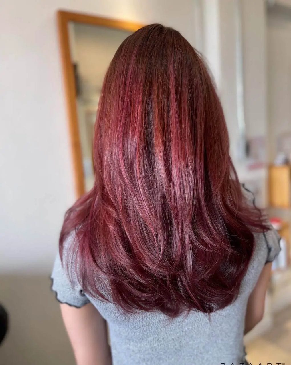 Berry-like red balayage on deep brunette with graceful layers.