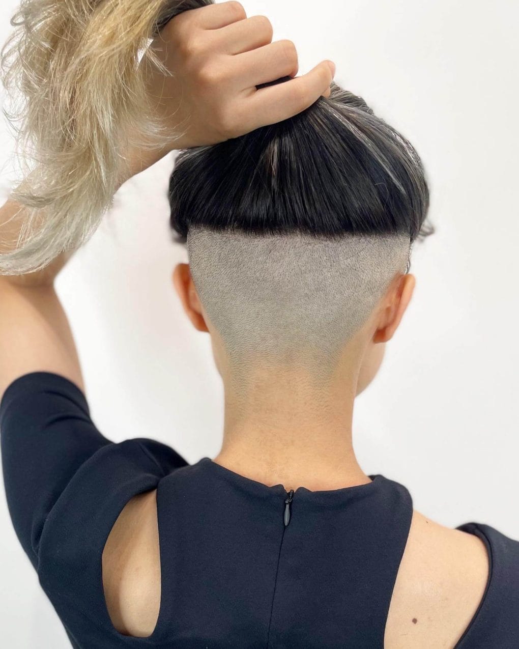 Long hair with a shaved back, transitioning to blonde balayage tips.