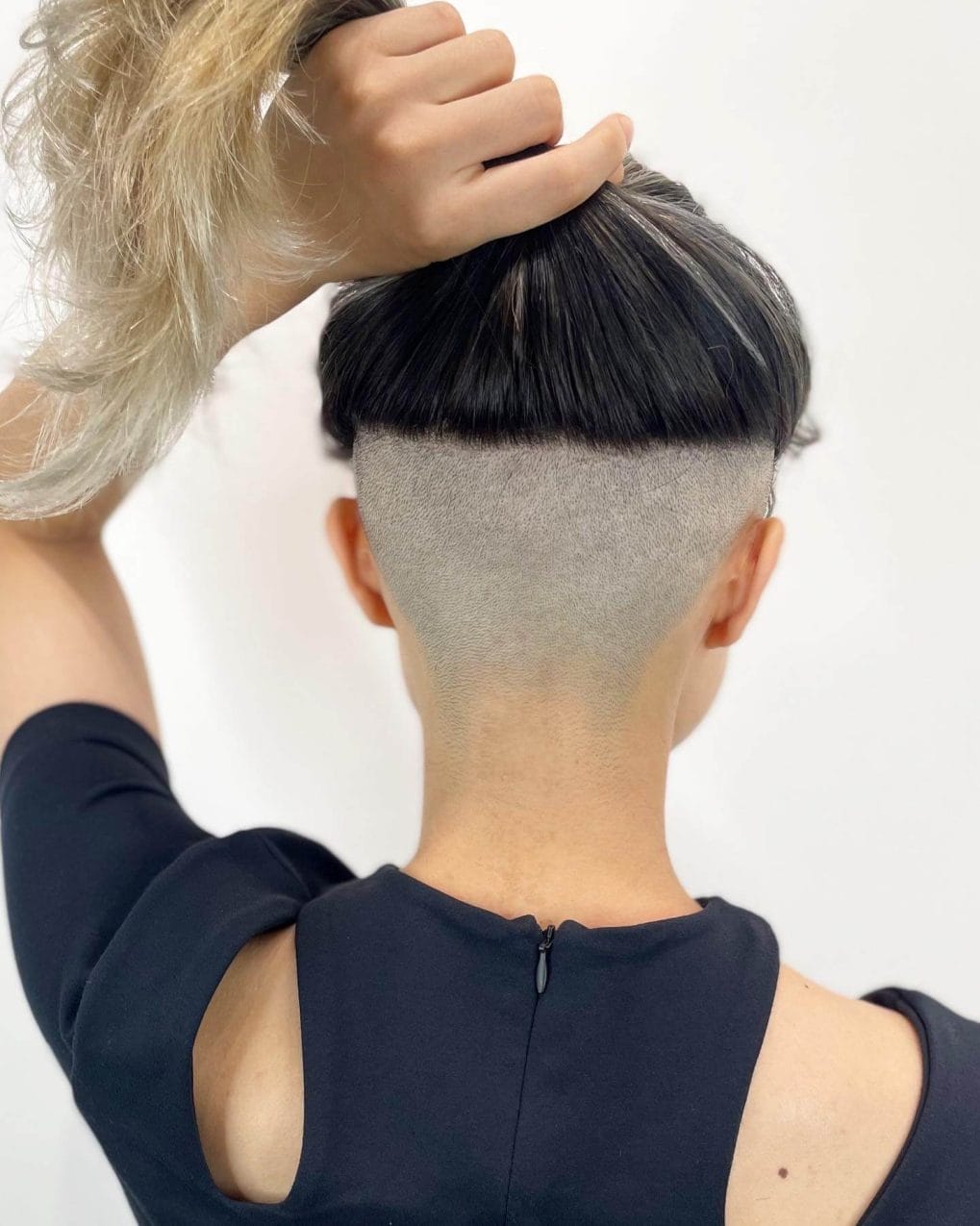 Long hair with a shaved back, transitioning to blonde balayage tips.