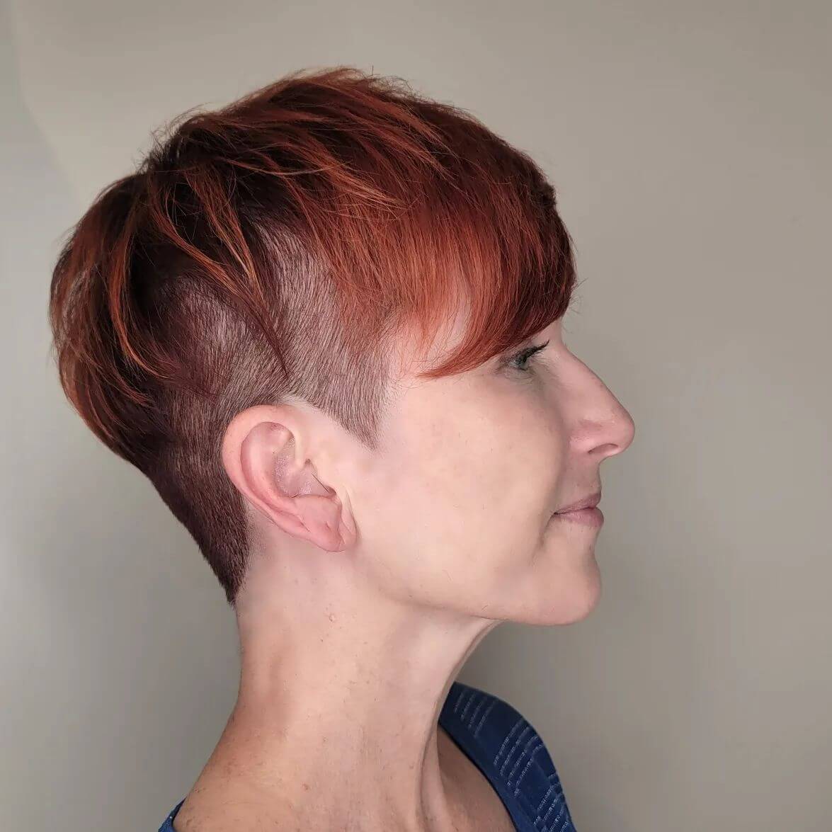 Vibrant copper-red pixie with sleek undercut.