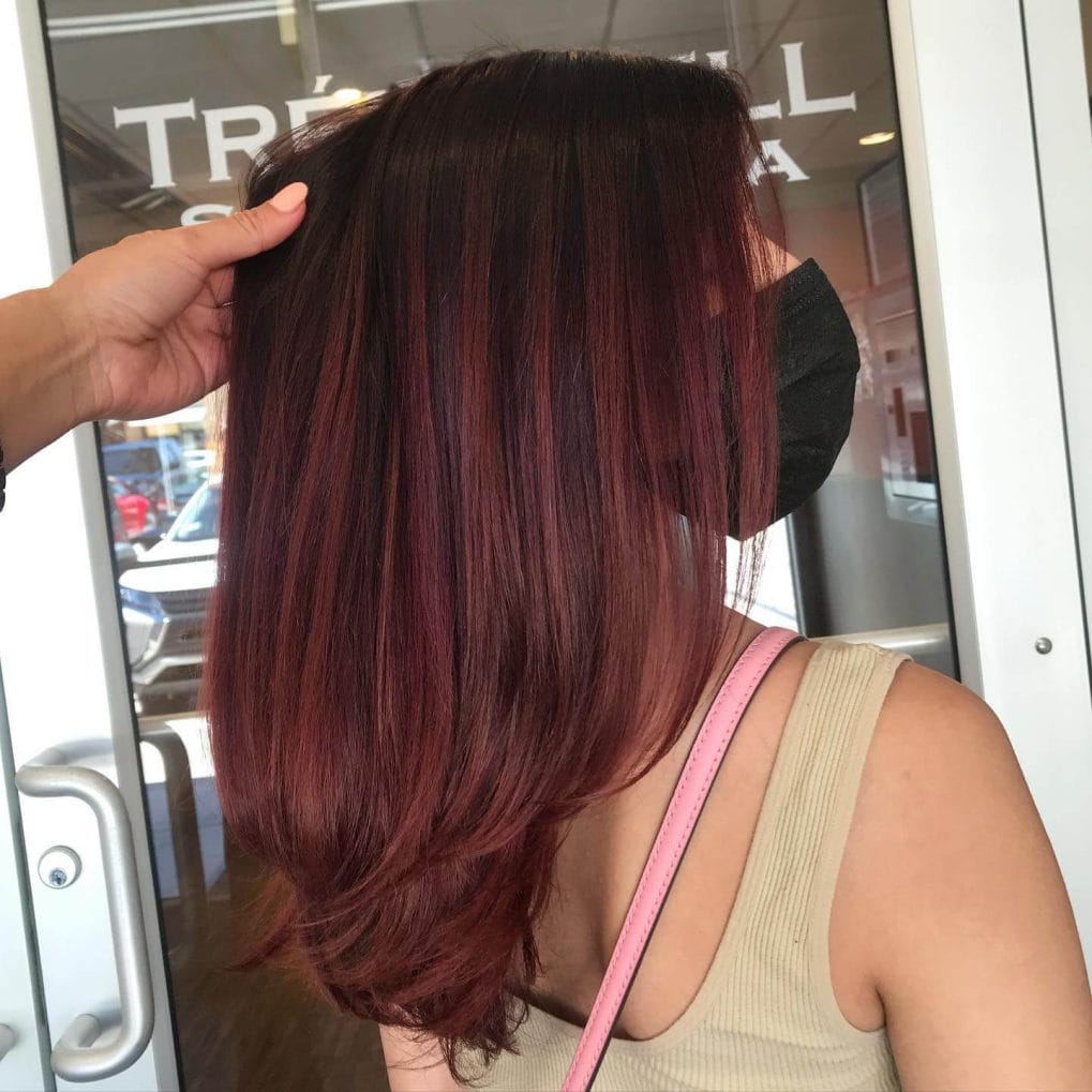 Bold red balayage contrast on angled lob, textured layers.